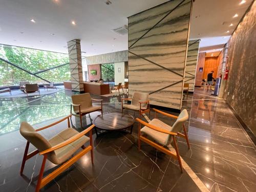 a lobby with chairs and a table in a building at Studio Time 1312 - Luxo - Ponta Verde - Maceió-AL in Maceió