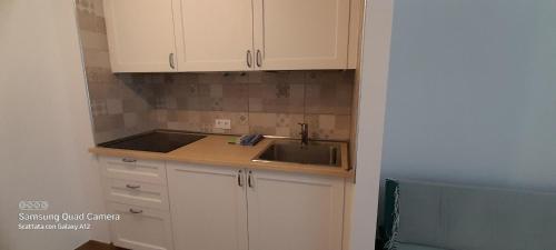 kuchnia z białymi szafkami i zlewem w obiekcie Loft 105 w Corralejo