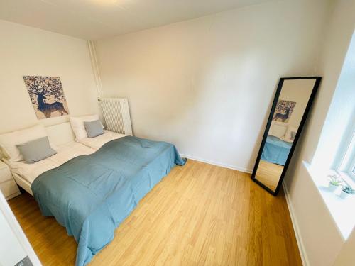 a bedroom with a bed and a mirror at aday - Reberbansgade Central Apartment in Aalborg