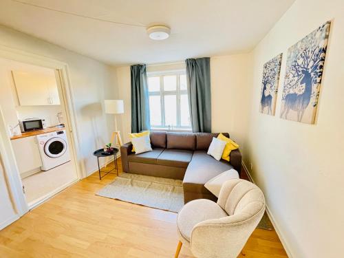 a living room with a couch and a window at aday - Reberbansgade Central Apartment in Aalborg
