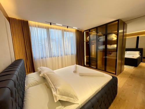 a bedroom with a large bed and a large window at Queens Luxury Apartments Tirana in Tirana