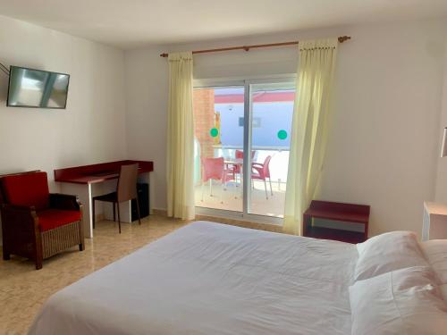 a bedroom with a bed and a table and a balcony at Hospedium Hotel Continental in Mojácar