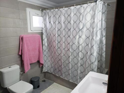 a bathroom with a toilet and a shower curtain at Maison du Cap Bon,Ben Hamida in El Haouaria