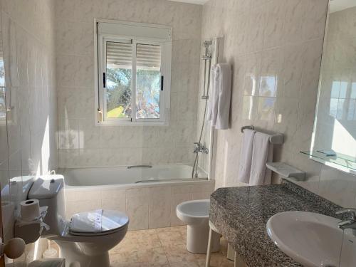 a bathroom with a tub and a toilet and a sink at Hospedium Hotel Continental in Mojácar
