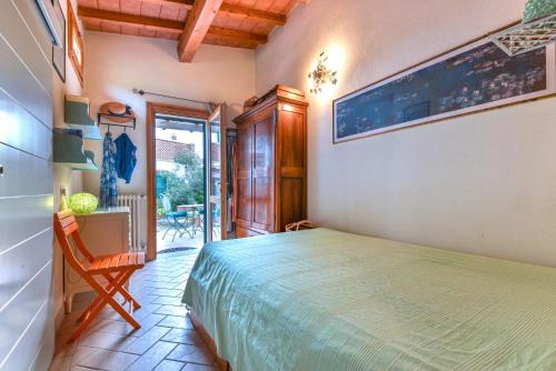 a bedroom with a bed and a table and a chair at Casetta delle mimose in Seccheto