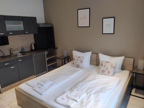 a room with a large white bed with pillows at Landhotel Mariensäule in Wernstein am Inn