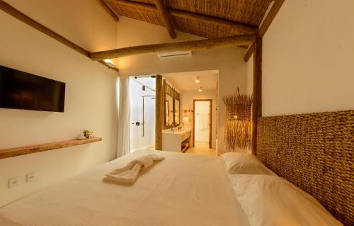 a bedroom with a bed with a towel on it at Pousada Nossa Casa Cumuruxatiba in Cumuruxatiba