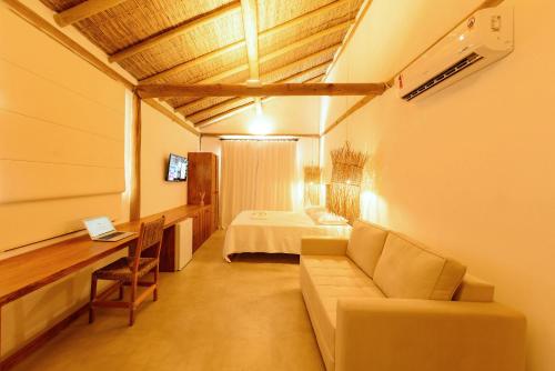 昆幕露夏其巴的住宿－Pousada Nossa Casa Cumuruxatiba，客厅配有沙发和1张床