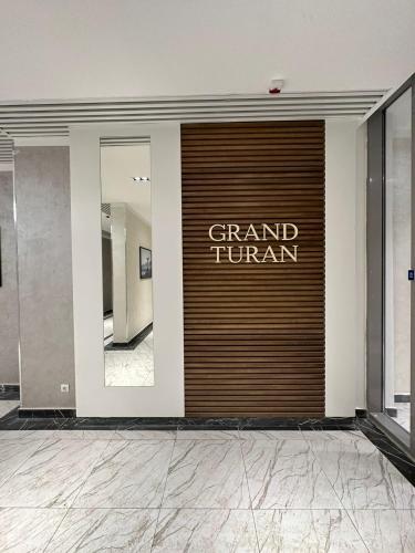 eine Haustür mit dem Namen Grand Turnan drauf. in der Unterkunft Жилой комплекс Гранд Туран in Taldykolʼ
