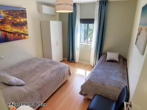 Un dormitorio con 2 camas y una silla. en Apartment Beta - 2 Bedrooms, Private Rooftop Patio with Hot Tub, BBQ and View, en Ferragudo