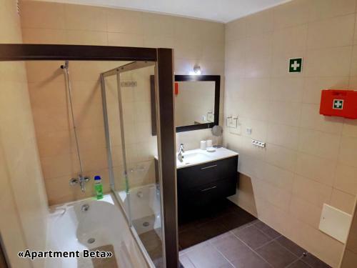 W łazience znajduje się wanna, umywalka i prysznic. w obiekcie Apartment Beta - 2 Bedrooms, Private Rooftop Patio with Hot Tub, BBQ and View w mieście Ferragudo