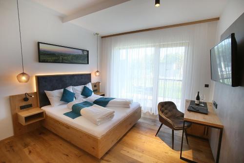 1 dormitorio con cama con almohadas azules y escritorio en Schlafgut FAM Steurer, en Jois