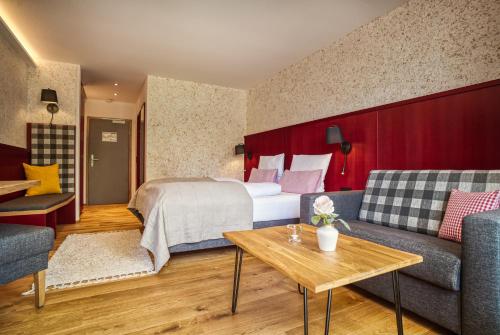 a hotel room with a bed and a couch at Landhaus Sommerau in Buchenberg