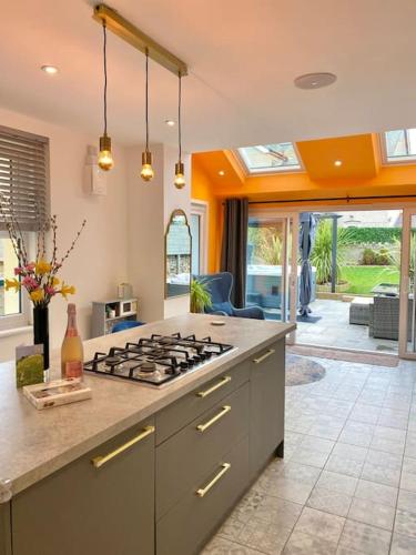 a kitchen with a stove top oven in a room at Tranquil Victorian Villa with Hot Tub & Sauna in Colwyn Bay