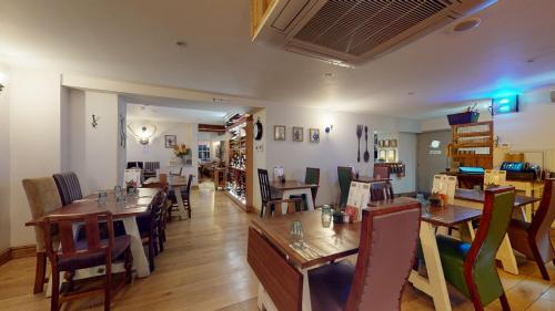 a dining room with wooden tables and chairs at The Devonshire Arms in Eckington