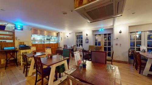um restaurante com mesas e cadeiras num quarto em The Devonshire Arms em Eckington
