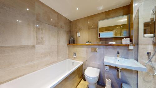 a bathroom with a tub and a toilet and a sink at The Devonshire Arms in Eckington