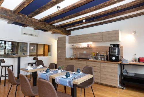 comedor con 2 mesas y cocina en Hôtel Lastiry, en Sare