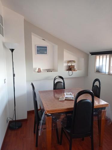 a dining room with a wooden table and chairs at Appartamento mansardato iPatrizi in Moncalieri