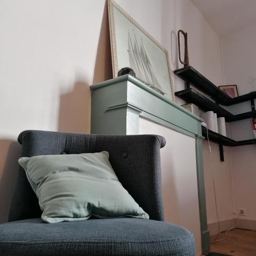 une chaise bleue avec un oreiller au-dessus de la cheminée dans l'établissement Dormir À La Rochelle 1 avec Parking, à La Rochelle