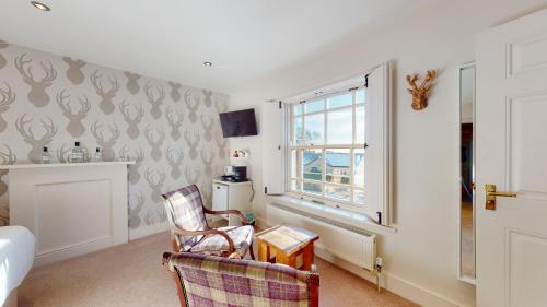 a living room with two chairs and a window at The Devonshire Arms in Eckington