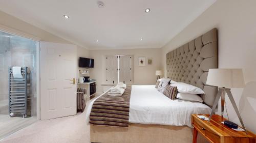 a bedroom with a large bed with a large headboard at The Devonshire Arms in Eckington