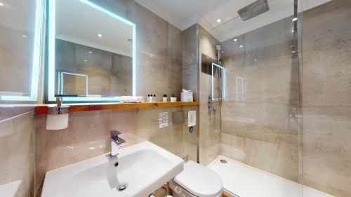 a bathroom with a sink and a toilet and a shower at The Devonshire Arms in Eckington