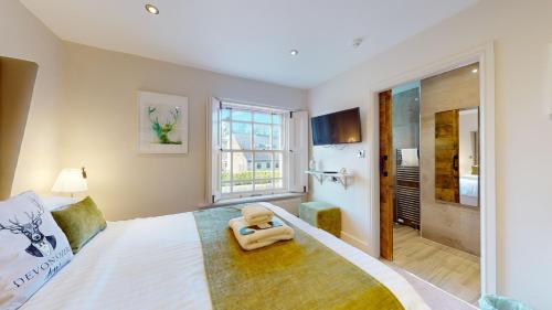 a bedroom with a large bed and a bathroom at The Devonshire Arms in Eckington