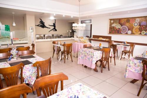 a dining room with tables and chairs in a restaurant at Hotel Village in Garanhuns