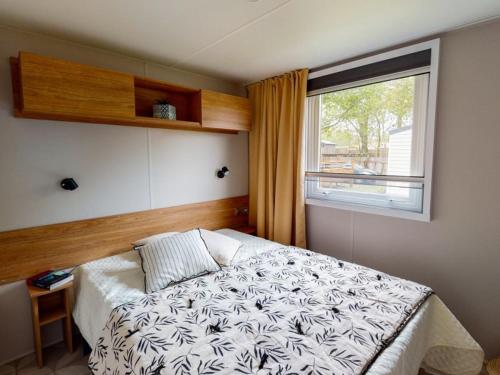 - une chambre avec un grand lit et une fenêtre dans l'établissement Camping Officiel Siblu Les Viviers, à Lège-Cap-Ferret