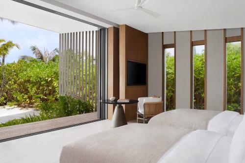 a bedroom with a large window with a view of the ocean at The Ritz-Carlton Maldives, Fari Islands in North Male Atoll