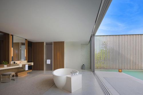 a bathroom with a bath tub and a large window at The Ritz-Carlton Maldives, Fari Islands in North Male Atoll