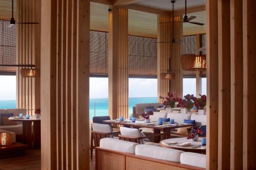 a dining room with tables and chairs and windows at The Ritz-Carlton Maldives, Fari Islands in North Male Atoll