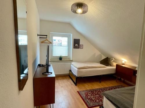 Zimmer im Dachgeschoss mit einem Bett und einem Fenster in der Unterkunft SPLENDiD: ☆Vintageflat In Center☆ in Hannover