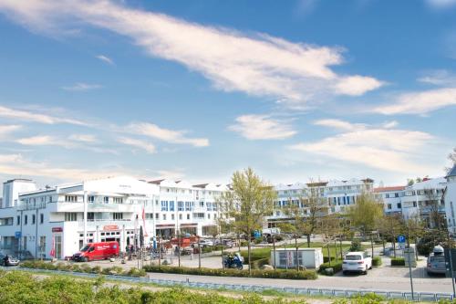 Une rangée de bâtiments blancs dans un parking dans l'établissement FeWo im maritimen Flair - 100m zu Strand & Seebrücke, à Zingst