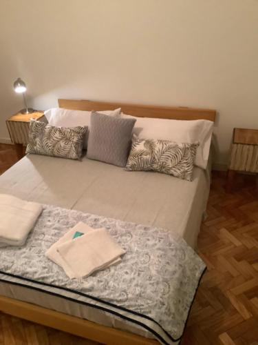 una cama con almohadas en una habitación en Pedro Goyena Departamento Facultad Filosofía y Letras en Buenos Aires