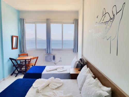1 dormitorio con 2 camas, mesa y ventana en Studio na Praia Vista Total TC1202, en Río de Janeiro