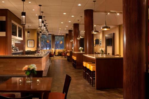 a restaurant with tables and chairs and a bar at Dallas/Fort Worth Airport Marriott in Irving