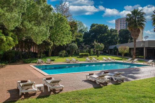 a swimming pool with lounge chairs and a resort at Lisbon Marriott Hotel in Lisbon