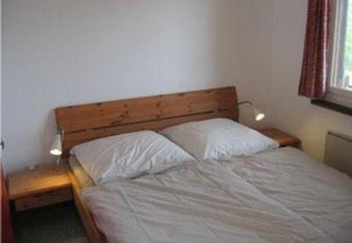 a bedroom with a bed with two white pillows at Chalet Hüsli in Giswil