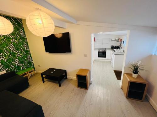 a living room with a couch and a table at Sunnyside Aparthotel Tropical suite, 10 min from Blackpool tower, outside space, free parking in Blackpool
