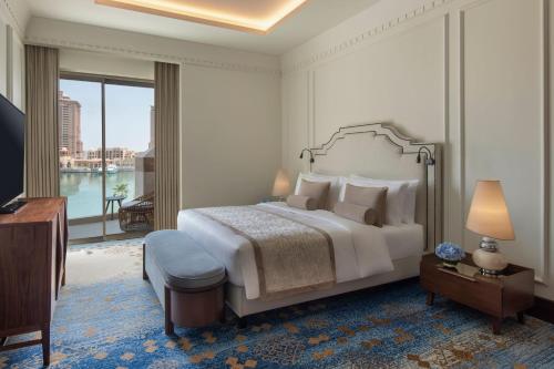 a bedroom with a large bed and a large window at The St. Regis Marsa Arabia Island, The Pearl Qatar in Doha