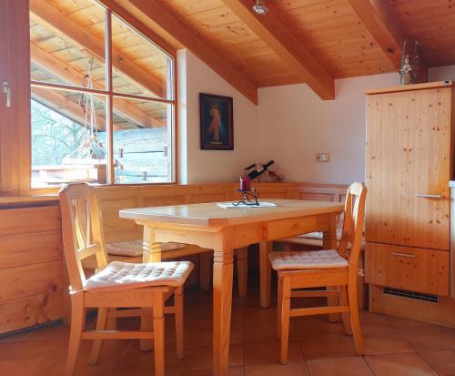 a dining room with a wooden table and chairs at Panoramaferienwohnung Resch in Bischofswiesen