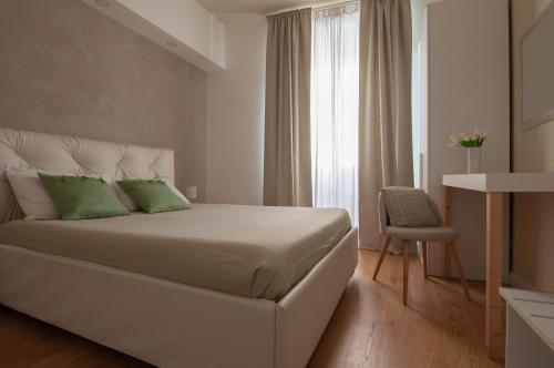 a bedroom with a bed with green pillows and a window at Urbanflat Repubblica Square in Rome