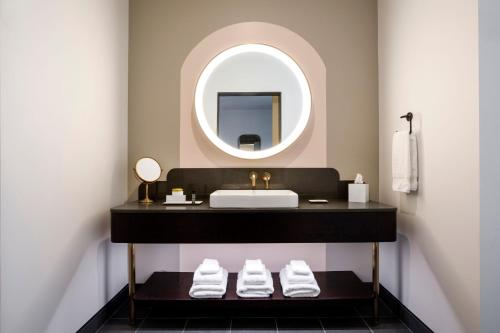 a bathroom with a sink and a mirror at Hotel Indy, Indianapolis, a Tribute Portfolio Hotel in Indianapolis