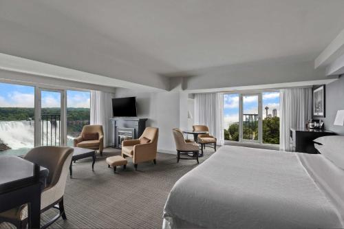 Cette chambre comprend un lit, un bureau et des chaises. dans l'établissement Sheraton Fallsview Hotel, à Niagara Falls