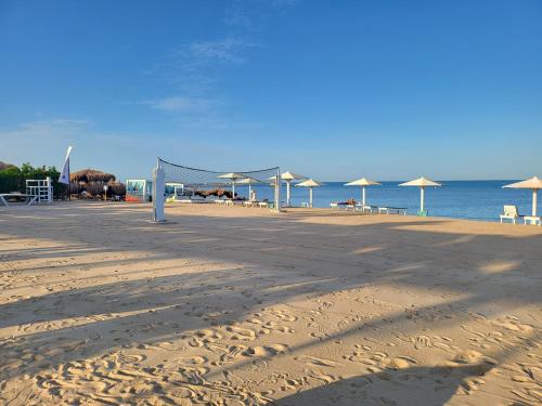une plage de sable avec des parasols et l'océan dans l'établissement Selena Bay Resort - Luxury 2 Bed Apt with Private Beach, à Hurghada