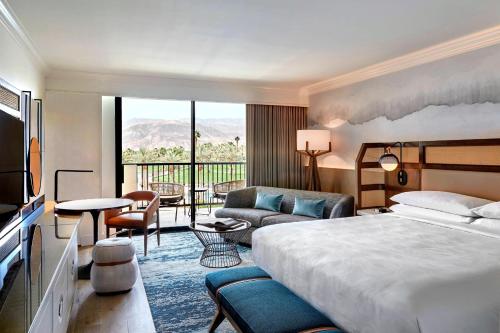 um quarto de hotel com uma cama e uma sala de estar em JW Marriott Desert Springs Resort & Spa em Palm Desert