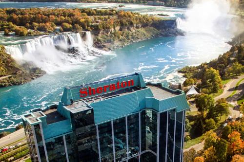 a building with a sign on it next to a waterfall at Sheraton Fallsview Hotel in Niagara Falls