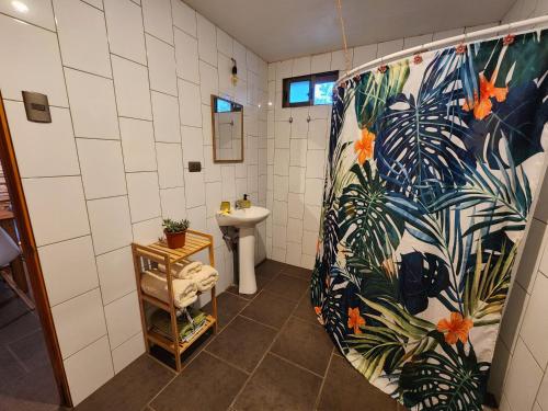 a bathroom with a sink and a shower curtain at Cabañas Kainga in Hanga Roa